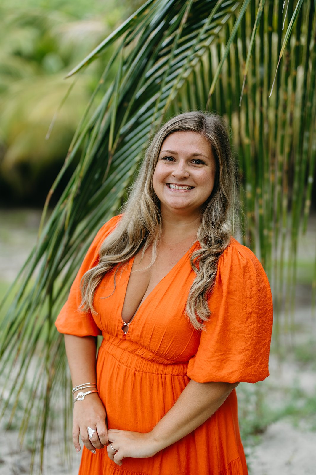 Mel, founder of The Virgin Islands Planner, smiling beneath a palm frond